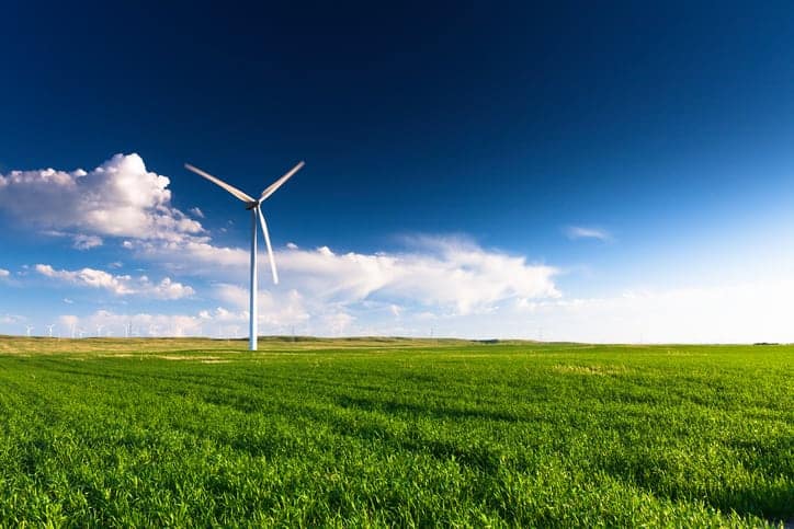 A lone windmill spinning above grassfields, doing its part to contribute to total wind power capacity from USWTD.