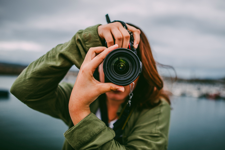 A woman taking a sideways photo and saving it in the ISO/IEC 10918 JPEG standard.