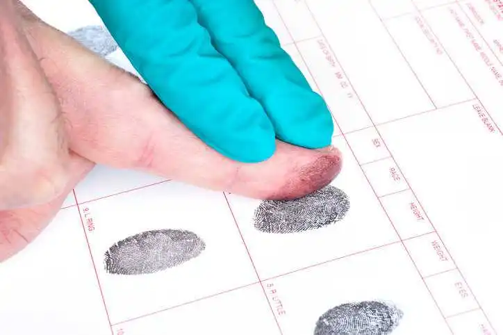 A criminal having their fingerprints taken.
