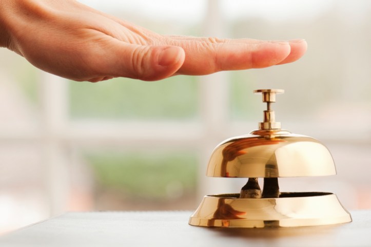 Hand tapping a gold bell for a customer complaint, which is handled with ISO 10002:2018