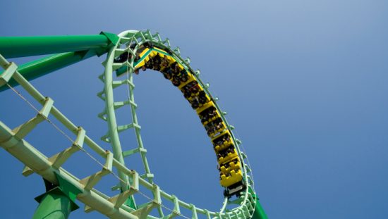 Green roller coaster loop providing ASTM F2291-20 amusement ride patrons with safe thrills.