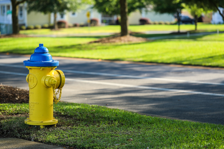 Yellow fire hydrant near road and tested to NFPA 291-2019