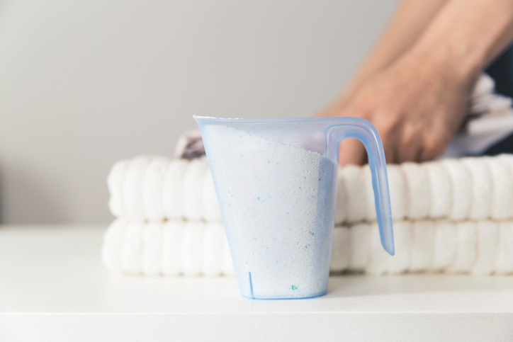 White hypochlorites following ANSI/AWWA B300-18 and piled as powder in pitcher.