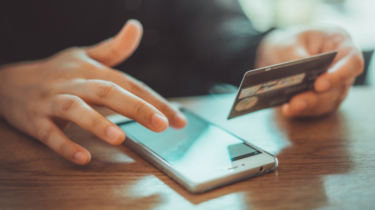 Businessman using credit card to check out online and keep his financial information secure.