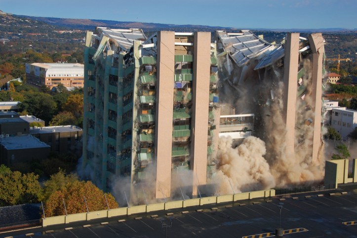Building being demolished under ANSI/ASSP A10.7-2018 explosive blasting agents requirements.