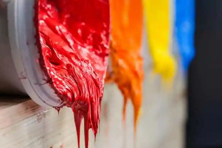 Printing ink spilling out in different colors from ANSI/NAPIM 177.1-2018 three-roll printing ink mills.