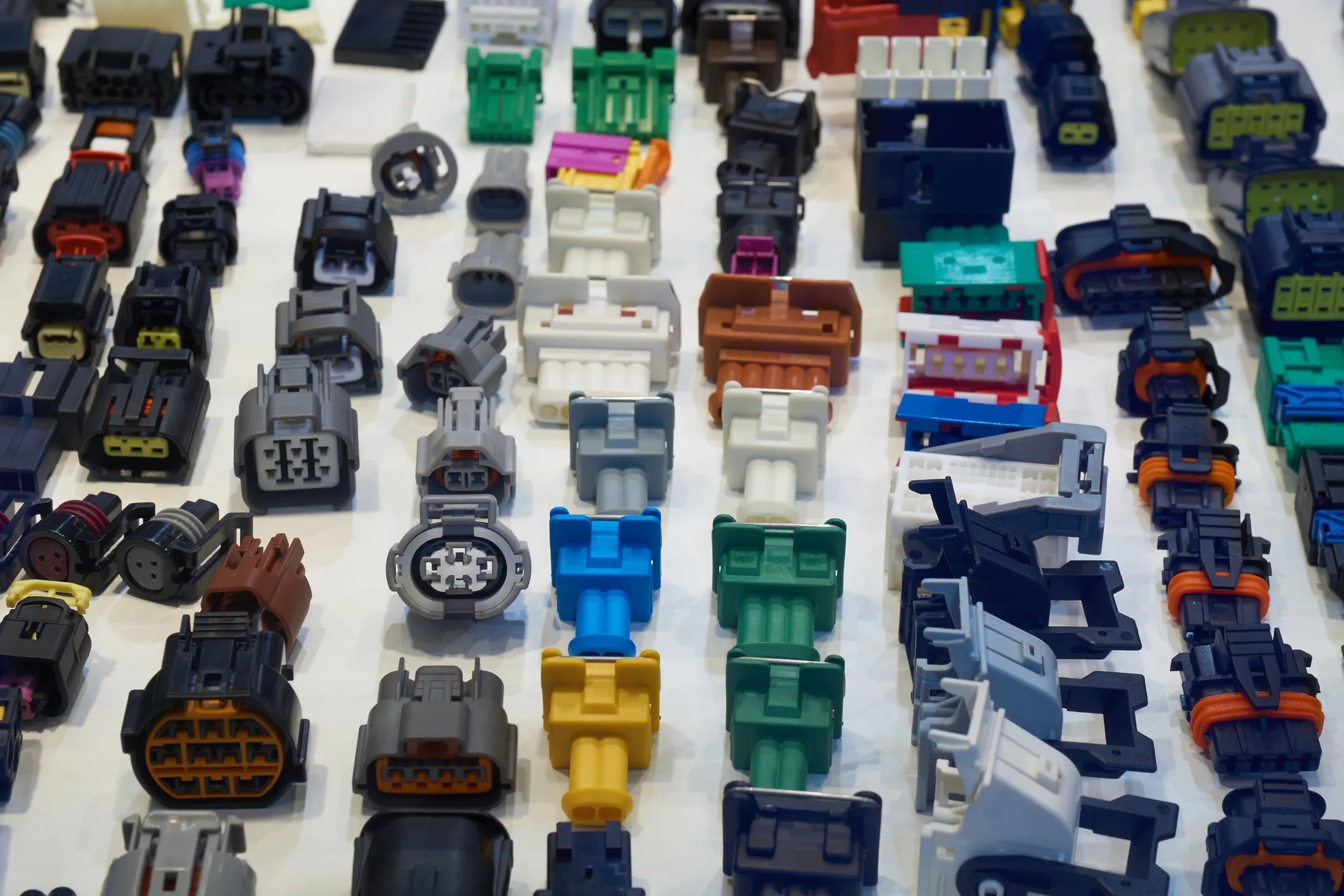 Colorful automotive electrical connectors lined up after being tested to ANSI C119.6-2024.