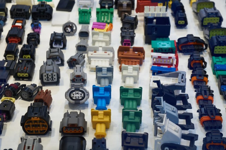Colorful automotive electrical connectors lined up after being tested to ANSI C119.6-2024.