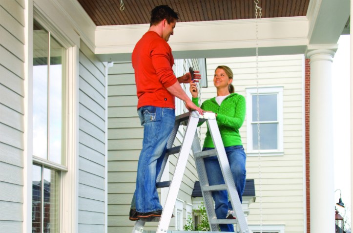 Couple in their new house practicing proper ladder safety.
