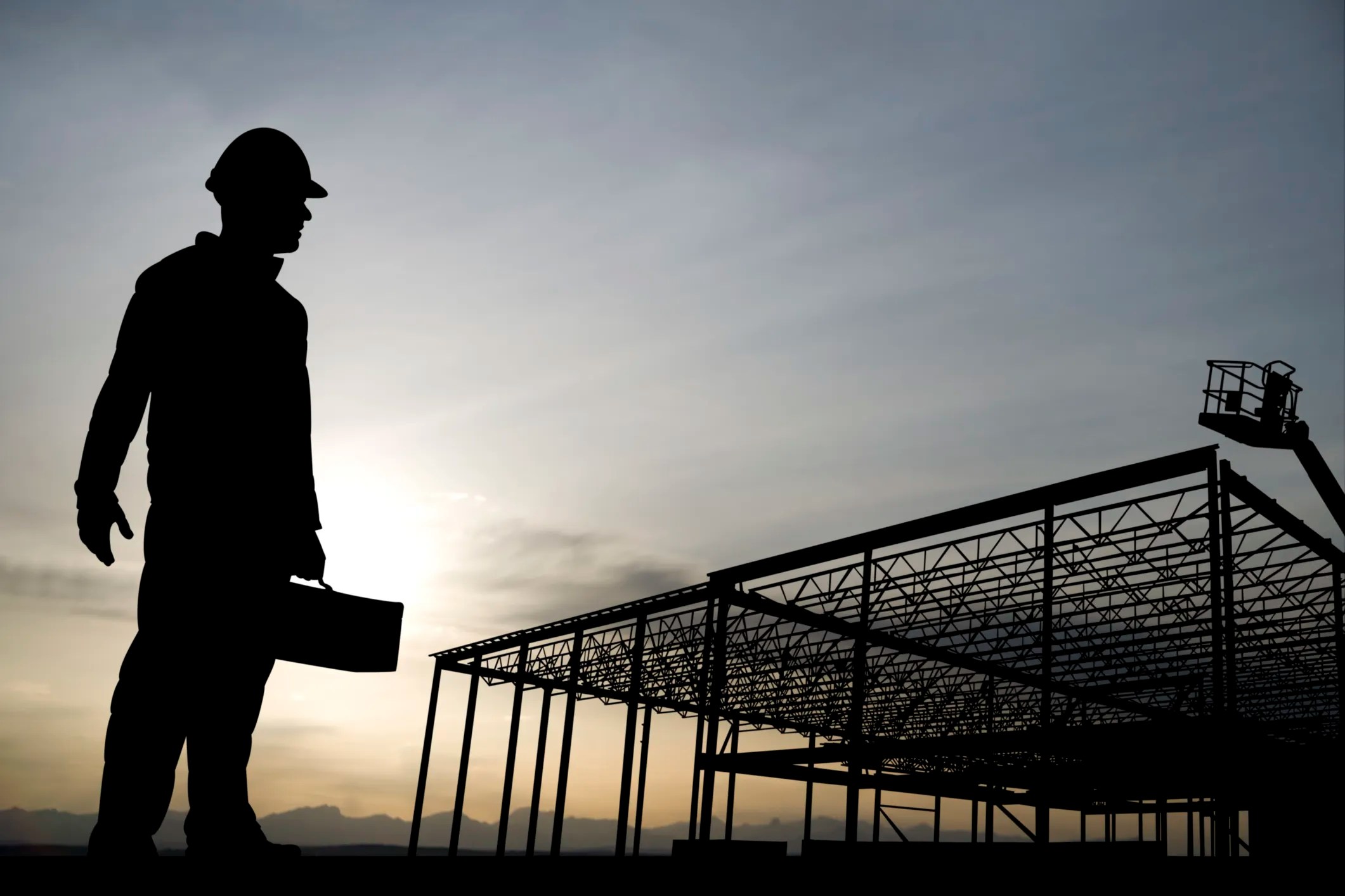 Worker silhouette carrying all ASME B30 safety standards for machine lifting equipment in construction.