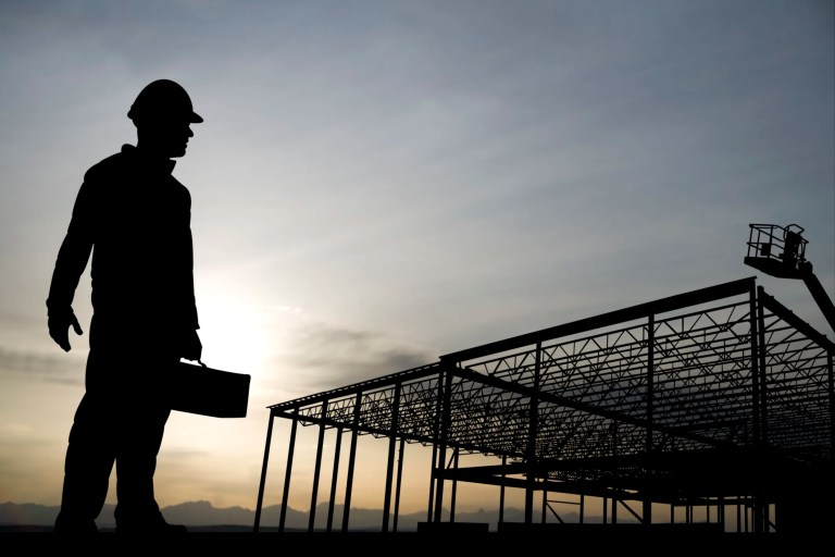Worker silhouette carrying all ASME B30 safety standards for machine lifting equipment in construction.