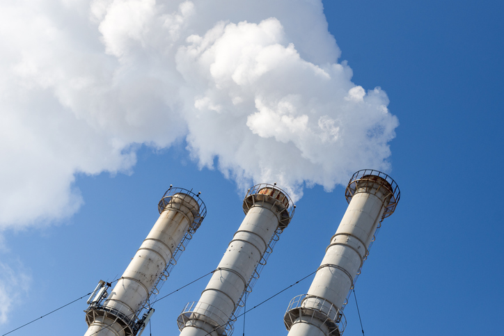 Greenhouse gases being emitted by smokestacks and need of ISO 14064-1:2018 removal