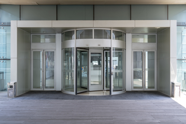 A building's revolving doors that follow ANSI/BHMA A156.27-2019