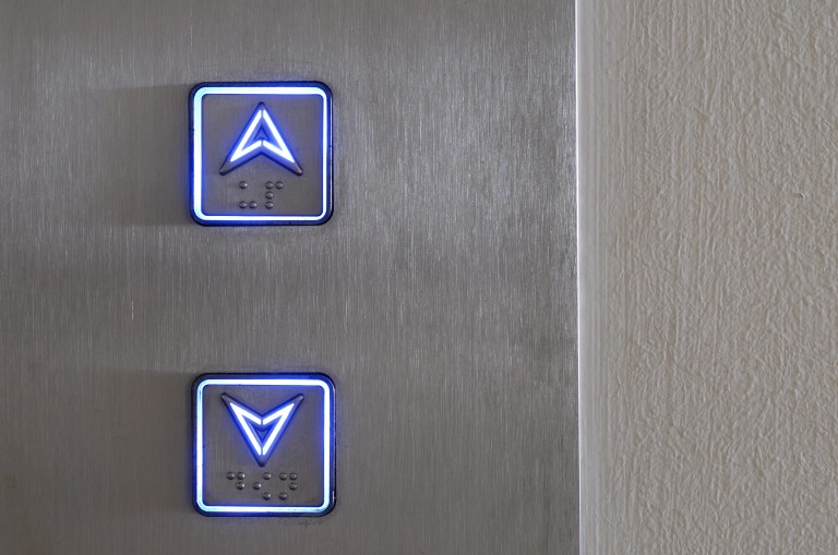 Up and down buttons of an elevator stay alight with ASME A15.5-2025 for electrical equipment.
