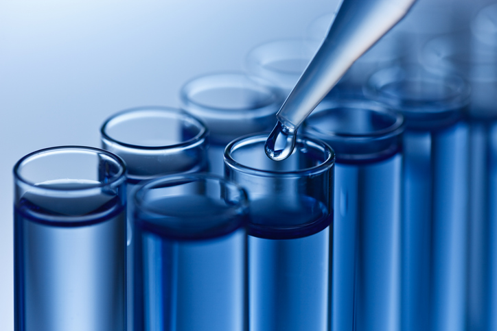 Pipette dripping chemical into test tube to conduct ANAB Accreditation for Per- and Polyfluoroalkyl Substances (PFAS).
