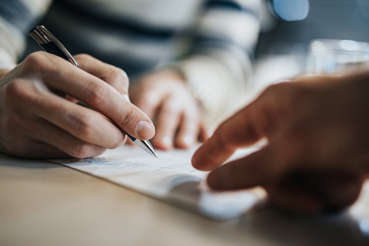 Closeup of hands conducting contract review through ISO/IEC 17025:2017.