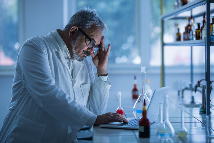 Researcher getting a headache after addressing nonconformities in laboratory through ISO/IEC 17025:2017.