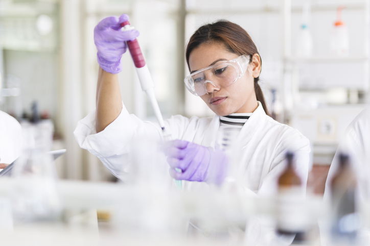 Scientist preparing pipette with sample prepared under ISO/IEC 17025:2017 terms and structural requirements.