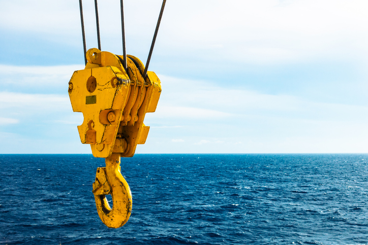 Crane hook that follows the safety guidelines in ASME B30.10 with the ocean in the background