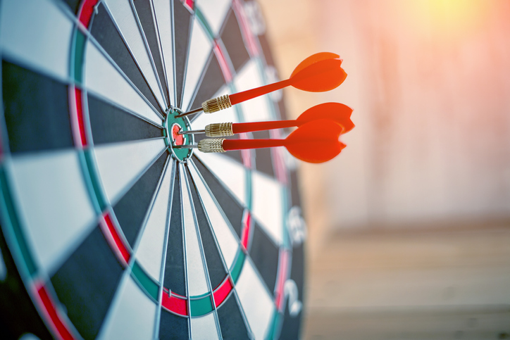 Three red darts find a bulls eye to depict accuracy and precision in ISO 5725-2:2019 that is repeatable.