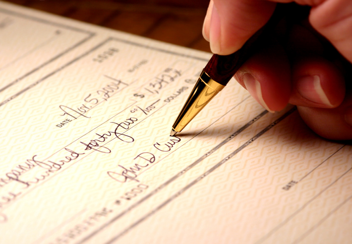 Signing a check with a gold pen to generate an ANSI X9.100-160-2-2020 MICR external processing code (EPC).