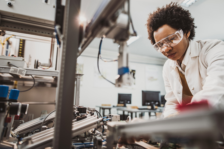 Woman testing equipment but in need of equipment calibration verification and validation under ISO/IEC 17025.