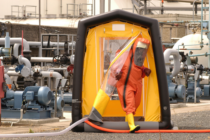 Doctor suited up stepping out of an ANSI/ISEA 113 decontamination shower.