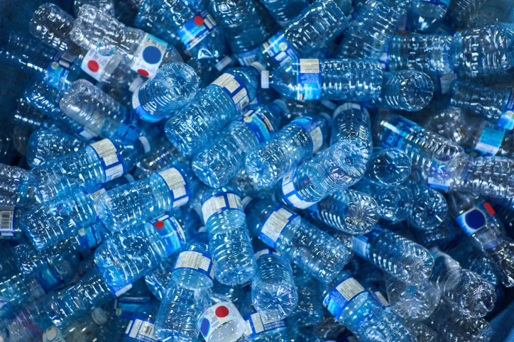 Pile of empty water bottles recycled with ASTM D7611-26 resin identification code (RIC).