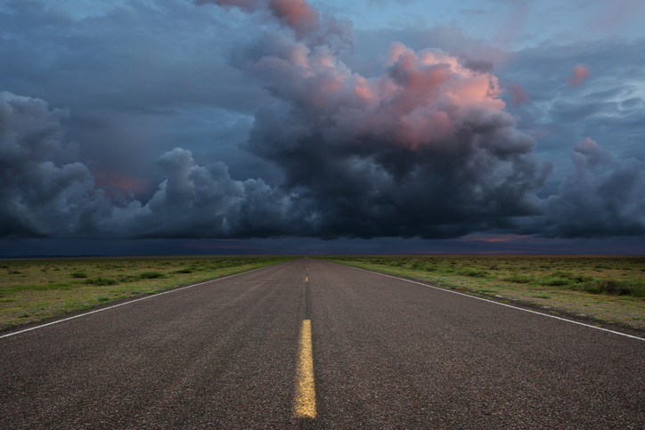 An empty road with a stormy sky that's representing trouble ahead and also ISO 22313:2020