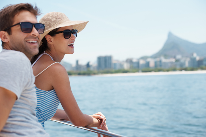 Happy couple wearing ANSI Z80 sunglasses on yacht