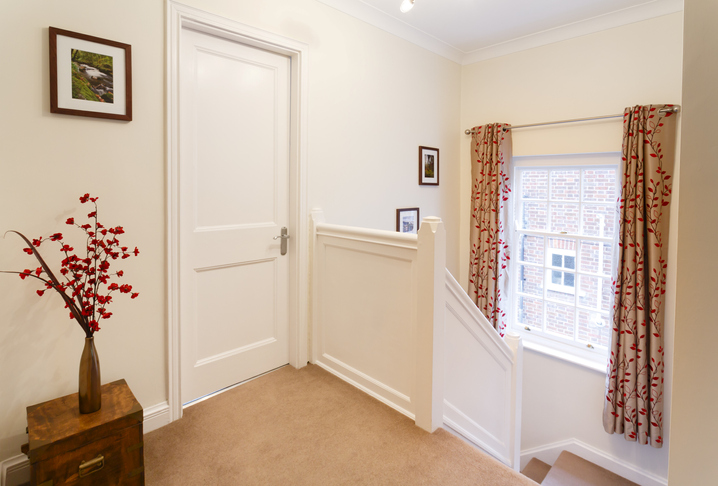 Upstairs landing in a house, next to a closed bedroom door