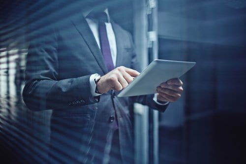 Businessman on tablet with some great Six Sigma competencies (under ISO standards).