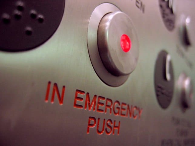When in an emergency, light a stuck elevator, push the in emergency button, as covered by ASME A17.1.