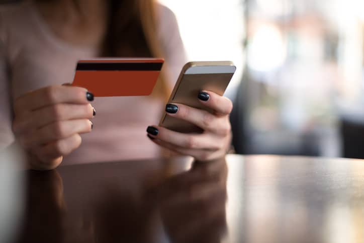 Woman entering her credit card info online thanks to ANSI/ASC X9 financial services industry standards.