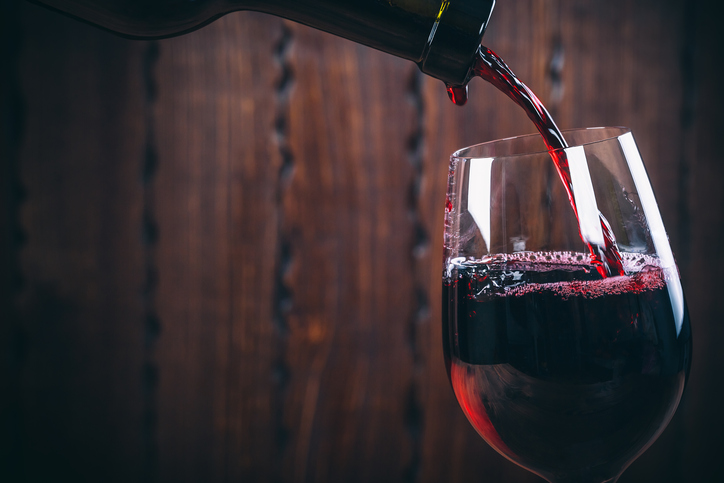 Pouring some good red wine, which has been made to ISO wine making standards.