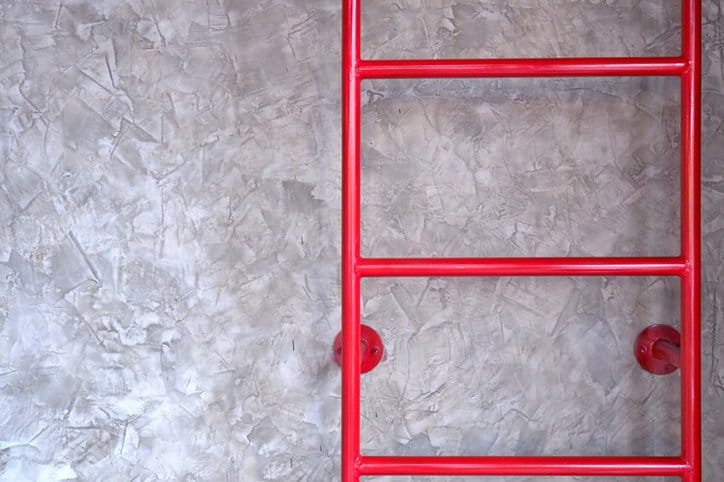 A bright red ladder in an industrial warehouse highlights the importance of safety ladders.