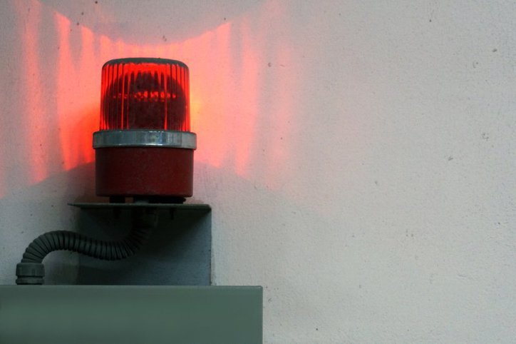 Bright red ANSI/ISA 18.2-2016 alarm system in action to prevent a factory accident.