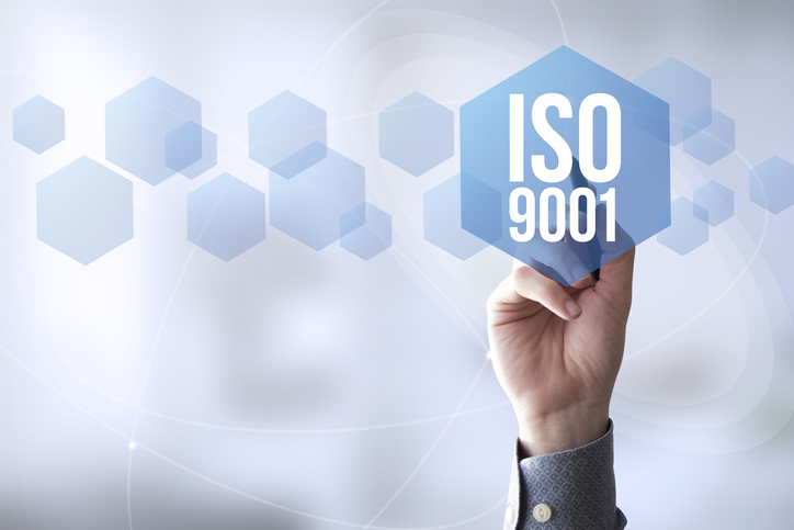 Hand reaching to ISO 9001:2015 graphic for quality management system requirements and certification / accreditation.
