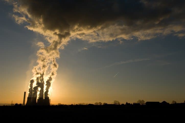 Power plant emits smoke and in need of ISO 14064 standards for quantifying greenhouse gas emissions.