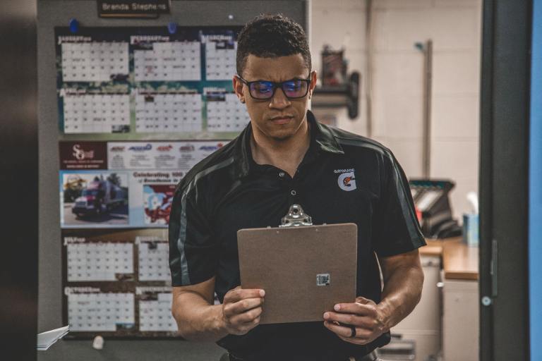 Man checking out his warehouse safety checklist to make sure his workplace is safe from hazards.