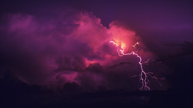 Red thunderstorm crashing in the clouds to represent overvoltages from not rating to ANSI C84.1-2020.