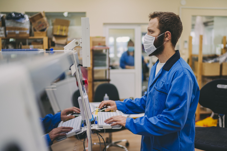 Masked engineer getting hands-on experience in the ANAB Industry-Recognized Apprenticeship Program (IRAP).