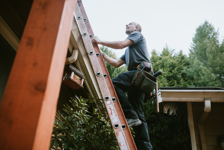 Man climbing ladder with three points of contact following safe inspection and environmental considerations.