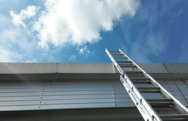 Metal extension ladder leading up to blue sky for safety.