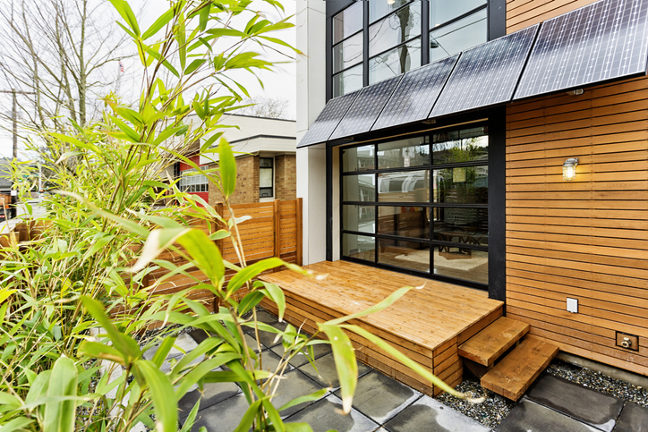 Wood home with greenery adhering to best International Energy Conservation Code (IECC) requirements.