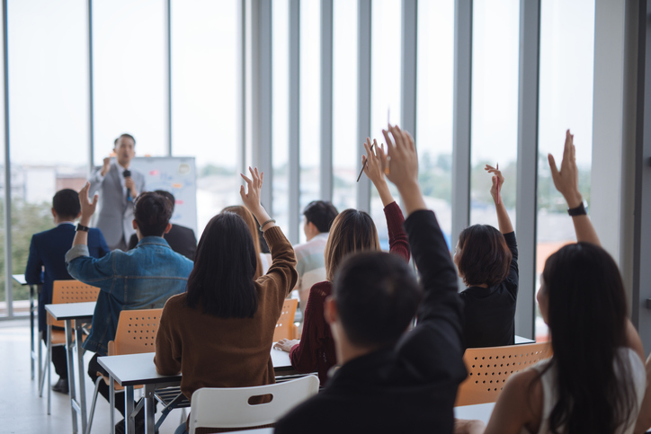 Attendants in an ANAB accredited certificate training course raising hands to participate.