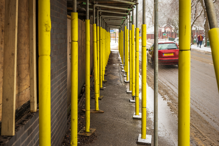 A walk under scaffolding on winter city day is safe from ANSI/ASSP A10.34-2021 construction requirements.