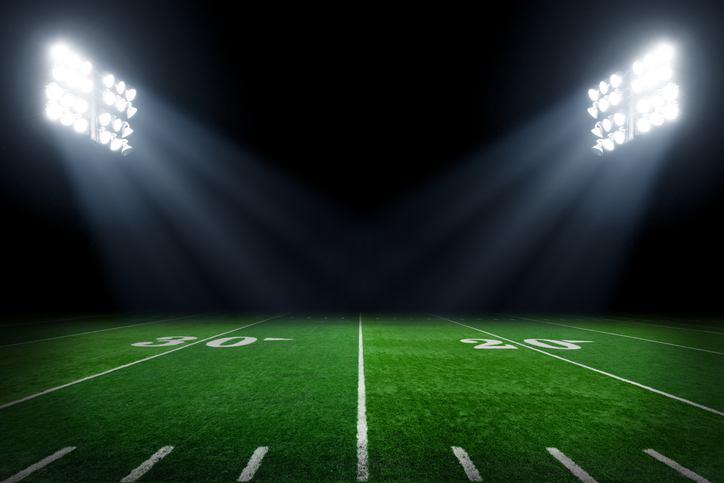 Verdant football field at night with stadium lights set properly with ANSI/IES RP-5-21 illumination.