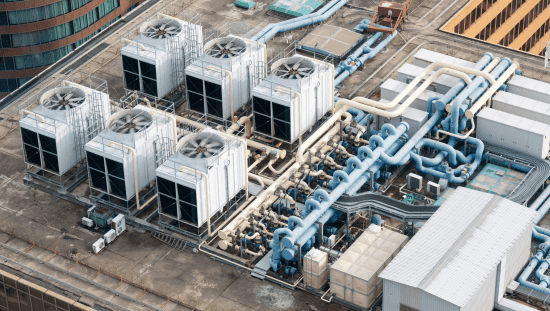 White mechanical building systems with spinning fans on HVAC systems safely following the 2021 International Mechanical Code (IMC).