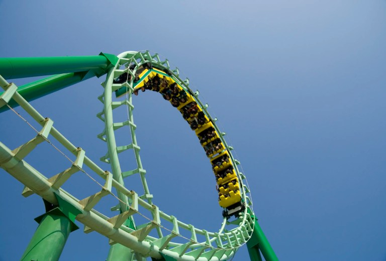 Green roller coaster loop providing ASTM F2291-25 amusement ride patrons with safe thrills.